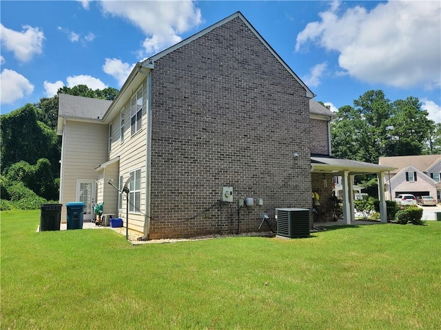 view of side of property with a patio area, central AC unit, a lawn, and brick siding