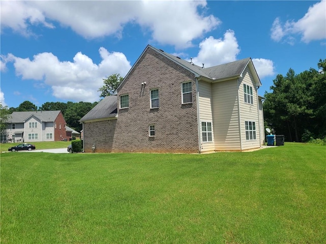 view of property exterior featuring brick siding and a lawn