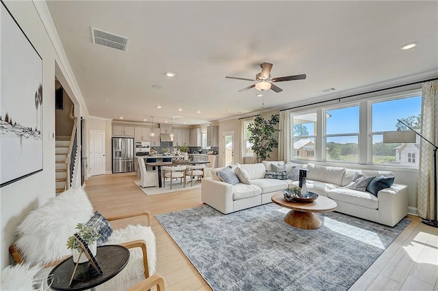 82 Sheryl Way, Loganville, GA 30052 - living area featuring ceiling fan, stairs, recessed lighting, ornamental molding, and light wood-type flooring