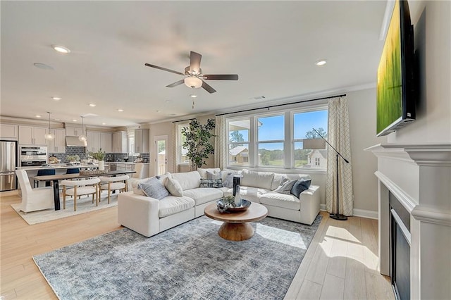 82 Sheryl Way, Loganville, GA 30052 - living room with ceiling fan, recessed lighting, a fireplace, light wood-style floors, and ornamental molding