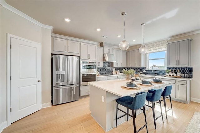 82 Sheryl Way, Loganville, GA 30052 - kitchen with appliances with stainless steel finishes, under cabinet range hood, gray cabinetry, ornamental molding, and decorative backsplash