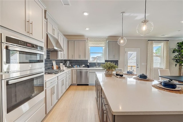 82 Sheryl Way, Loganville, GA 30052 - kitchen with appliances with stainless steel finishes, under cabinet range hood, backsplash, ornamental molding, and plenty of natural light