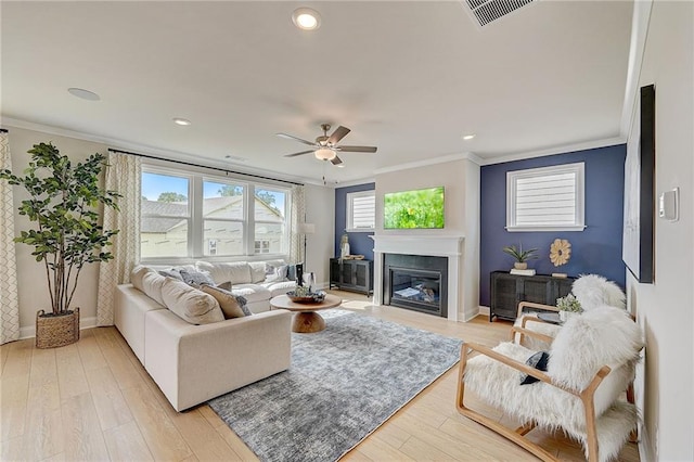 82 Sheryl Way, Loganville, GA 30052 - living area featuring ornamental molding, a ceiling fan, light wood-style floors, a glass covered fireplace, and recessed lighting