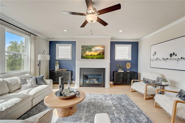 82 Sheryl Way, Loganville, GA 30052 - living area with ornamental molding, light wood finished floors, a ceiling fan, a glass covered fireplace, and recessed lighting