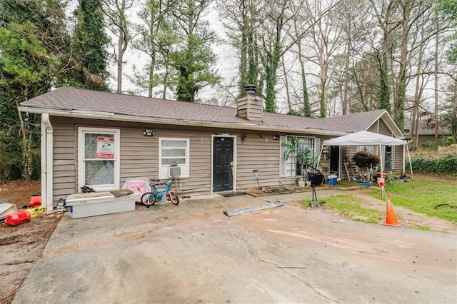 rear view of house featuring a patio and a chimney