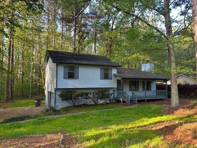 1106 Hardy Cir, Dallas, GA 30157 - tri-level home with a front yard, a porch, a garage, and a chimney