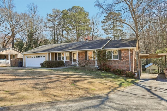 ranch-style home with brick siding, an attached garage, fence, driveway, and a front lawn