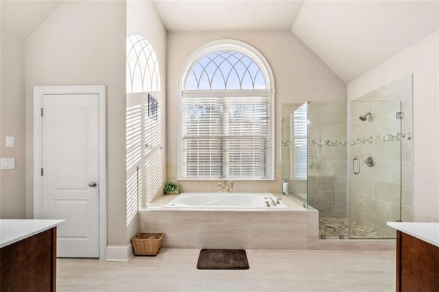 bathroom with shower with separate bathtub, vanity, and vaulted ceiling