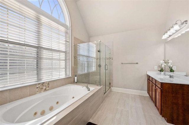 bathroom with plus walk in shower, vanity, and lofted ceiling