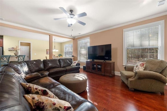 living room featuring ornamental molding, ceiling fan with notable chandelier, plenty of natural light, and dark wood-type flooring