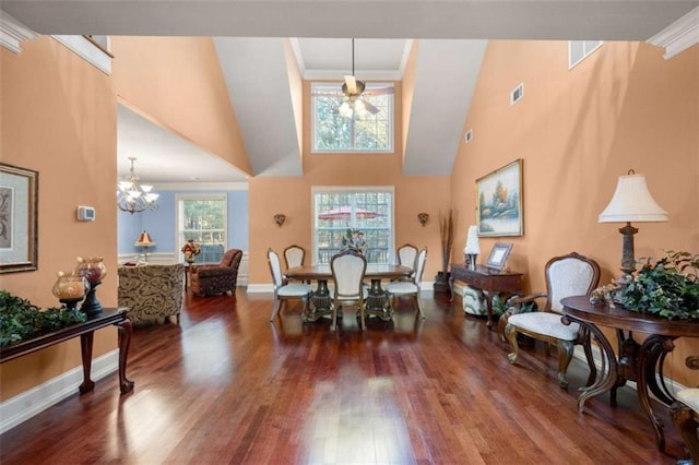 dining room with a chandelier, crown molding, high vaulted ceiling, and dark wood-type flooring