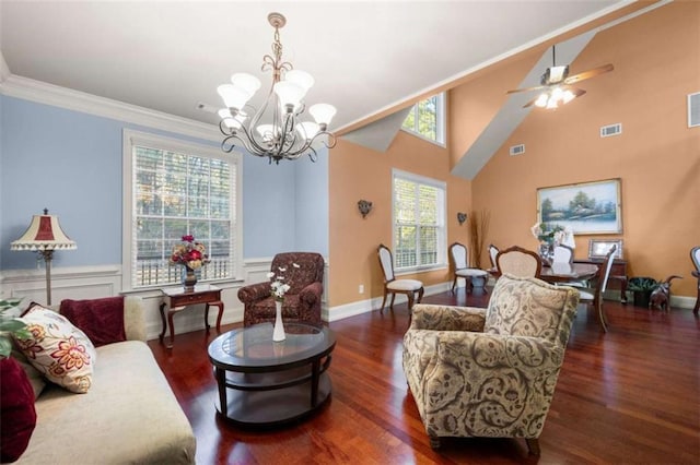 living room with dark hardwood / wood-style floors, ornamental molding, ceiling fan with notable chandelier, and a high ceiling