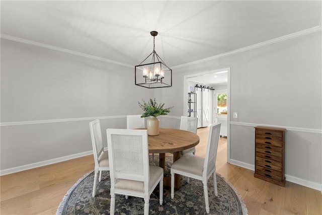 dining space featuring a chandelier, wood finished floors, ornamental molding, and baseboards