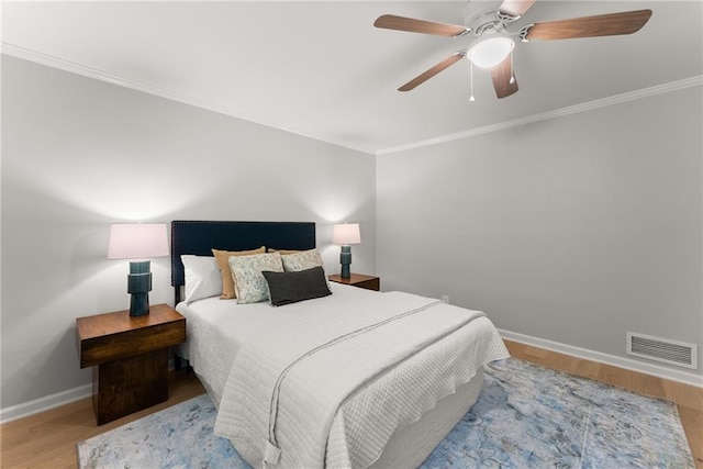 bedroom featuring wood finished floors, ornamental molding, baseboards, and a ceiling fan