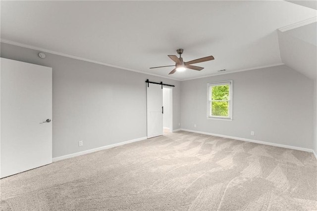 unfurnished bedroom with crown molding, light colored carpet, a barn door, baseboards, and ceiling fan
