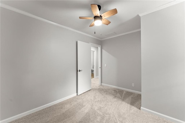 empty room with carpet floors, baseboards, ceiling fan, and crown molding