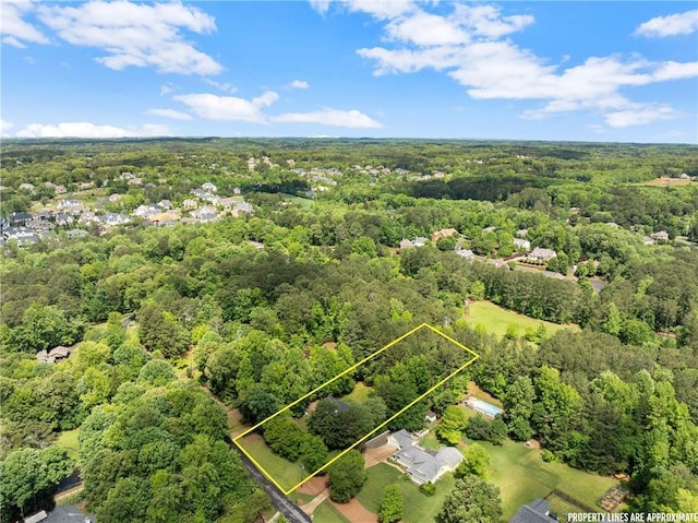 aerial view of property's location featuring a forest and property parcel outlined