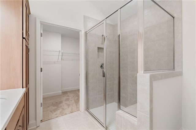 1216 Cedarcrest Blvd, Acworth, GA 30101 - full bathroom featuring a shower stall, a spacious closet, tile patterned flooring, vanity, and baseboards
