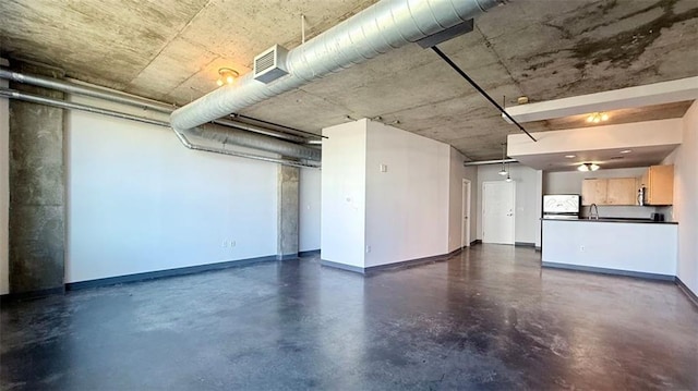 basement featuring sink and white fridge