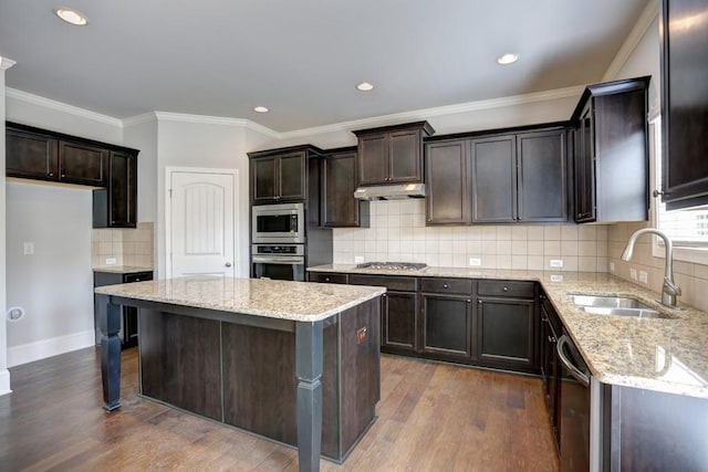 kitchen featuring light stone countertops, appliances with stainless steel finishes, dark wood-type flooring, sink, and a kitchen island