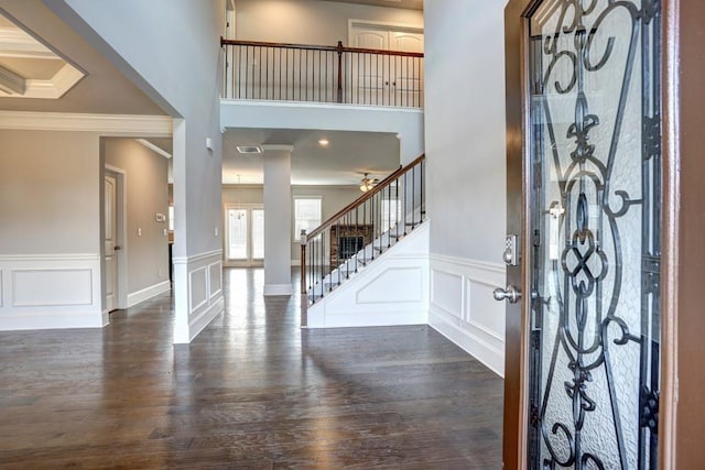 entrance foyer with dark wood-type flooring and ornamental molding