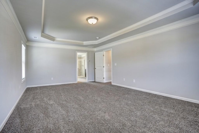 empty room featuring carpet floors, a tray ceiling, and crown molding