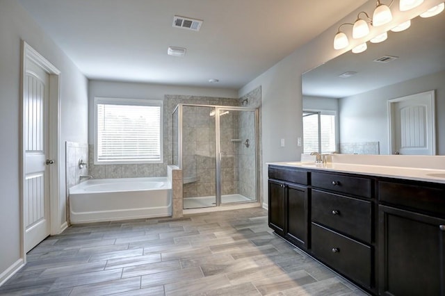 bathroom with vanity and separate shower and tub