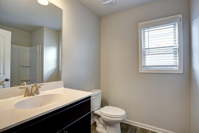 bathroom featuring hardwood / wood-style flooring, vanity, toilet, and walk in shower