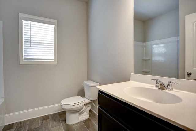 bathroom featuring a shower, vanity, and toilet