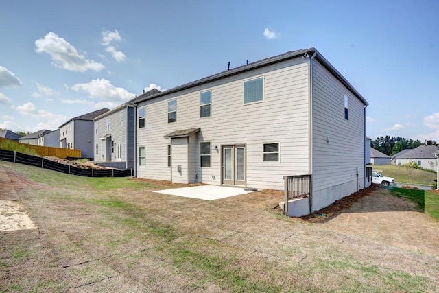 rear view of house featuring a lawn and a patio area