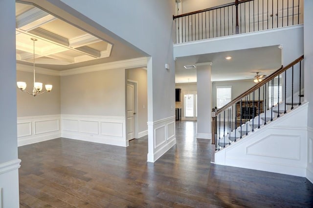 foyer with coffered ceiling, ceiling fan with notable chandelier, ornamental molding, beam ceiling, and dark hardwood / wood-style flooring