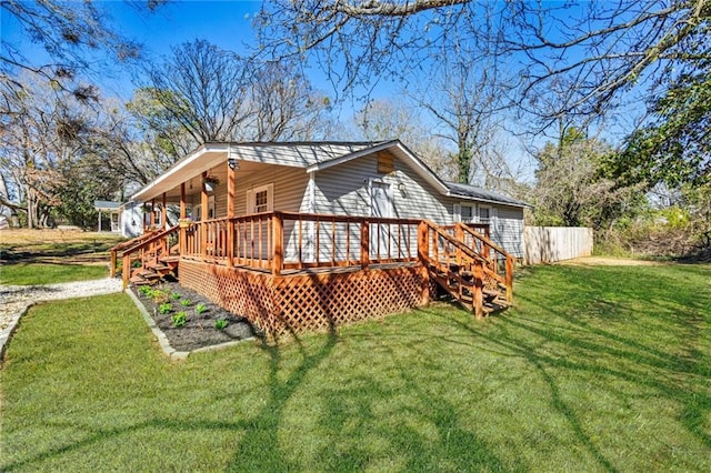 back of property with a lawn and a wooden deck