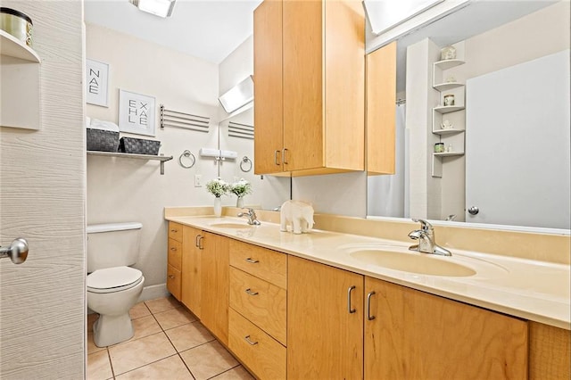 bathroom with tile patterned flooring, vanity, and toilet