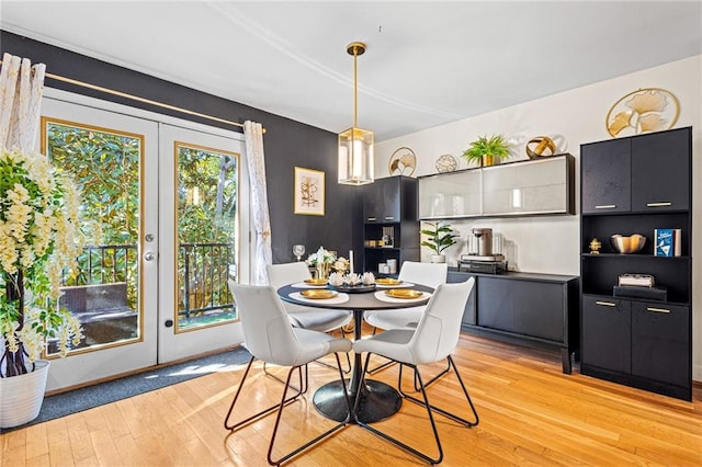 dining space with french doors and light hardwood / wood-style flooring