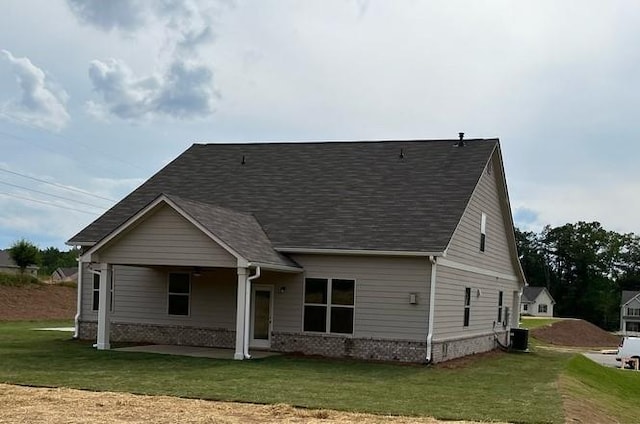 view of front of home featuring a front lawn and central AC