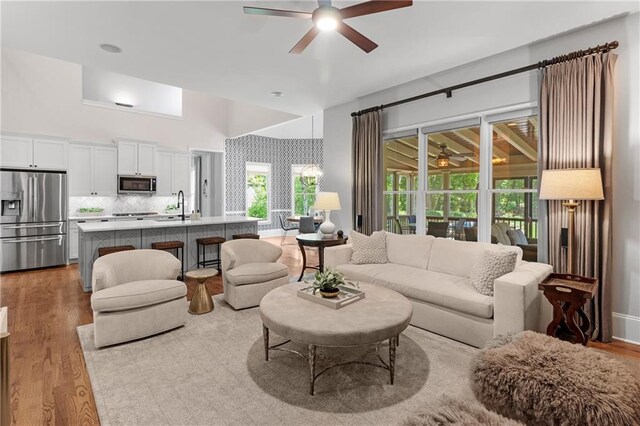 living area featuring light wood-type flooring and ceiling fan