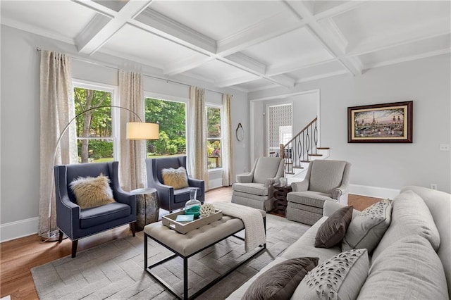 living area featuring baseboards, coffered ceiling, wood finished floors, and beamed ceiling