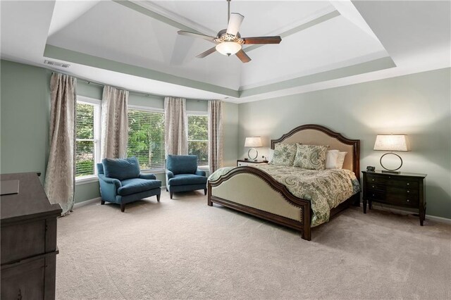 bedroom featuring light colored carpet, baseboards, a tray ceiling, and visible vents