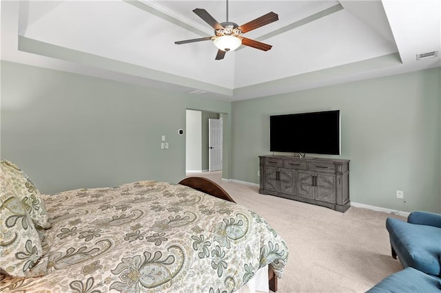 carpeted bedroom featuring visible vents, a ceiling fan, baseboards, and a tray ceiling