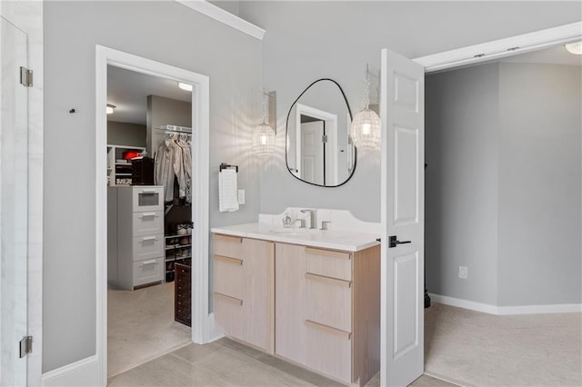full bath featuring a stall shower, baseboards, a spacious closet, and vanity