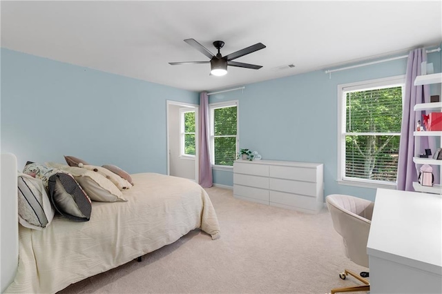 carpeted bedroom with ceiling fan and visible vents