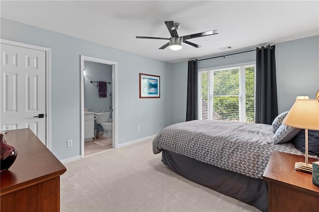 bedroom featuring ceiling fan, visible vents, baseboards, connected bathroom, and light carpet