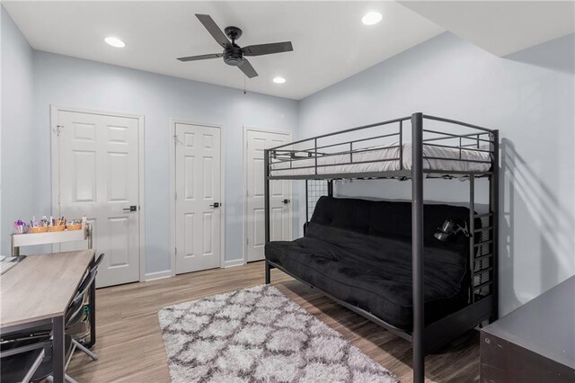 bedroom with ceiling fan, multiple closets, recessed lighting, baseboards, and wood finished floors
