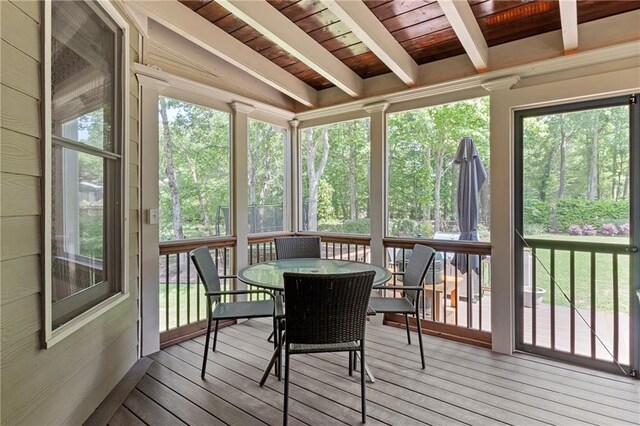 sunroom / solarium featuring outdoor dining area and beam ceiling