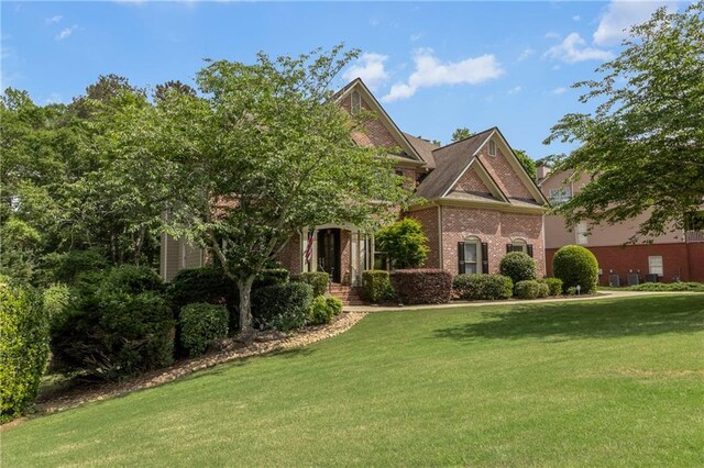 view of front of home with brick siding and a front lawn