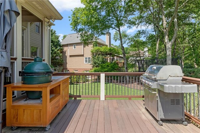 wooden deck featuring a lawn and grilling area