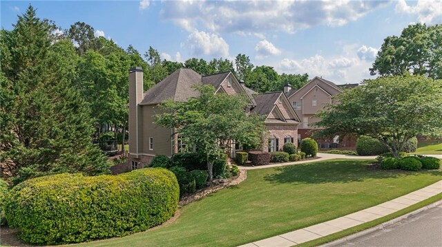 view of front of home with a front lawn and a chimney