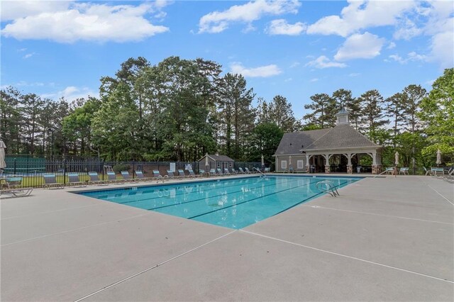 community pool featuring a patio and fence