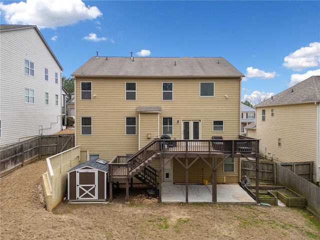 rear view of house with a deck, a patio area, and a shed