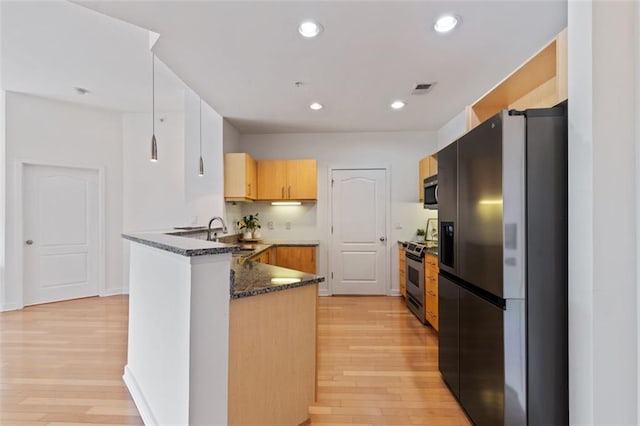 390 17th St NW Unit 6036, Atlanta, GA 30363 - kitchen with stainless steel appliances, a peninsula, light wood-type flooring, dark stone counters, and a sink
